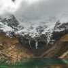 body of water near snow-covered mountain